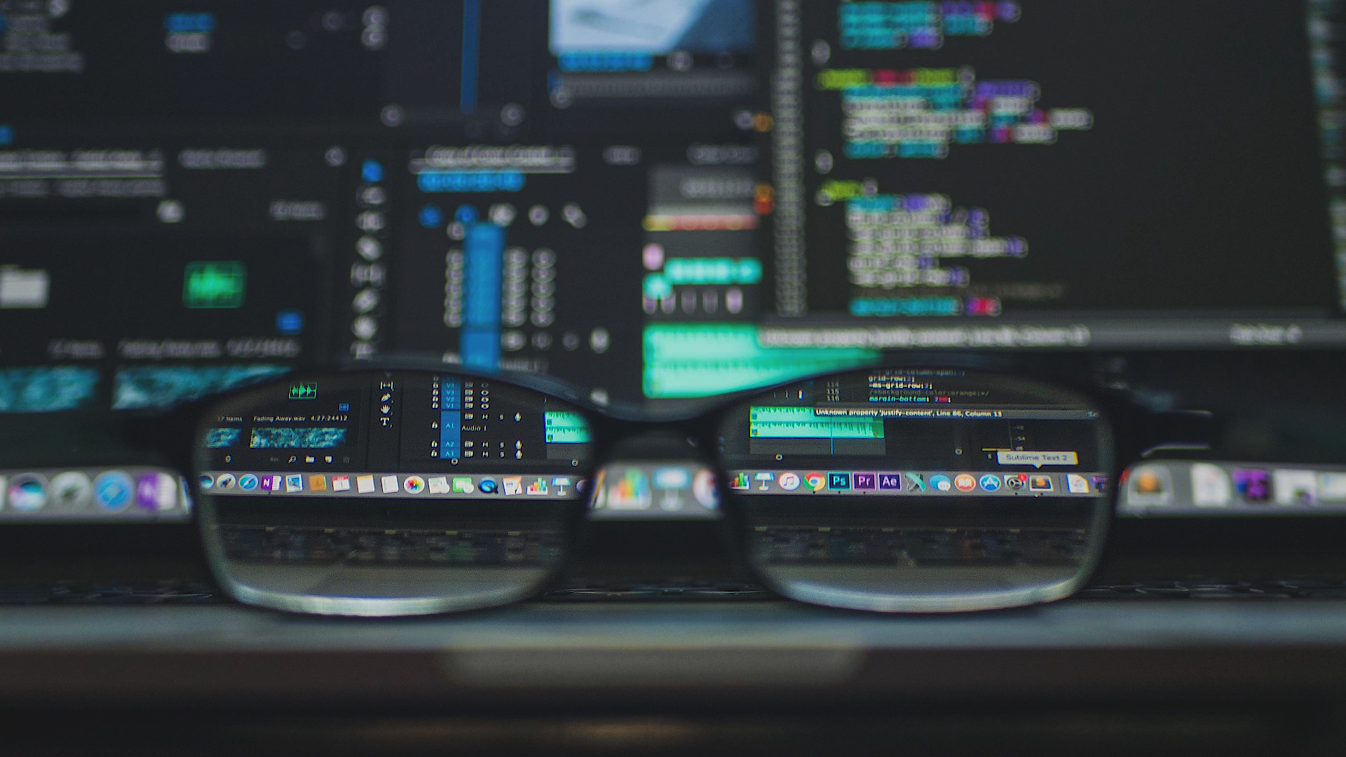 Glasses in focus in front of code on a screen