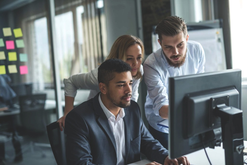 Team crowded around a computer working together